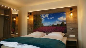 Ein Schlafzimmer mit einem großen Bett, einem Nachttisch, einem Holzkopfteil mit einem Gemälde und einem Kleiderschrank.