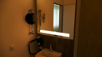Ein Badezimmer mit Spiegel, Waschbecken und Handtuchhalter.
