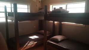 Dormitorio con literas, dos ventanas, ventilador de techo e iluminación.