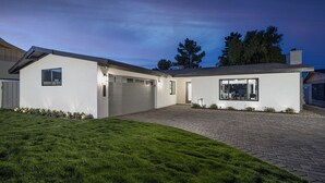 A modern house with a garage, a covered patio, and a well-maintained lawn. - 5 Min to Old Town • Heated Pool • Hot Tub • Fire Pit (Scottsdale)