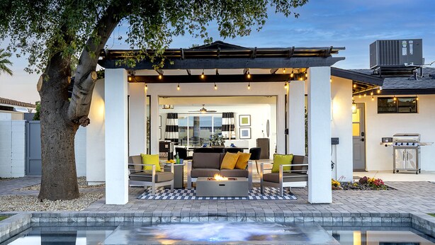 A covered outdoor seating area with a pool in the foreground. - 5 Min to Old Town • Heated Pool • Hot Tub • Fire Pit (Scottsdale)