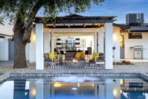 A covered outdoor seating area with a pool in the foreground. - 5 Min to Old Town • Heated Pool • Hot Tub • Fire Pit (Scottsdale)