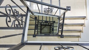 A staircase with a metal railing and a glass door at the top.