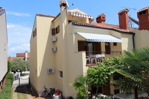 A residential building with a balcony, a bicycle, and a small garden area. - Apartments Darko (Rovinj)