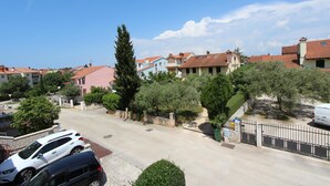 Una calle residencial con casas, autos estacionados y cielo despejado.