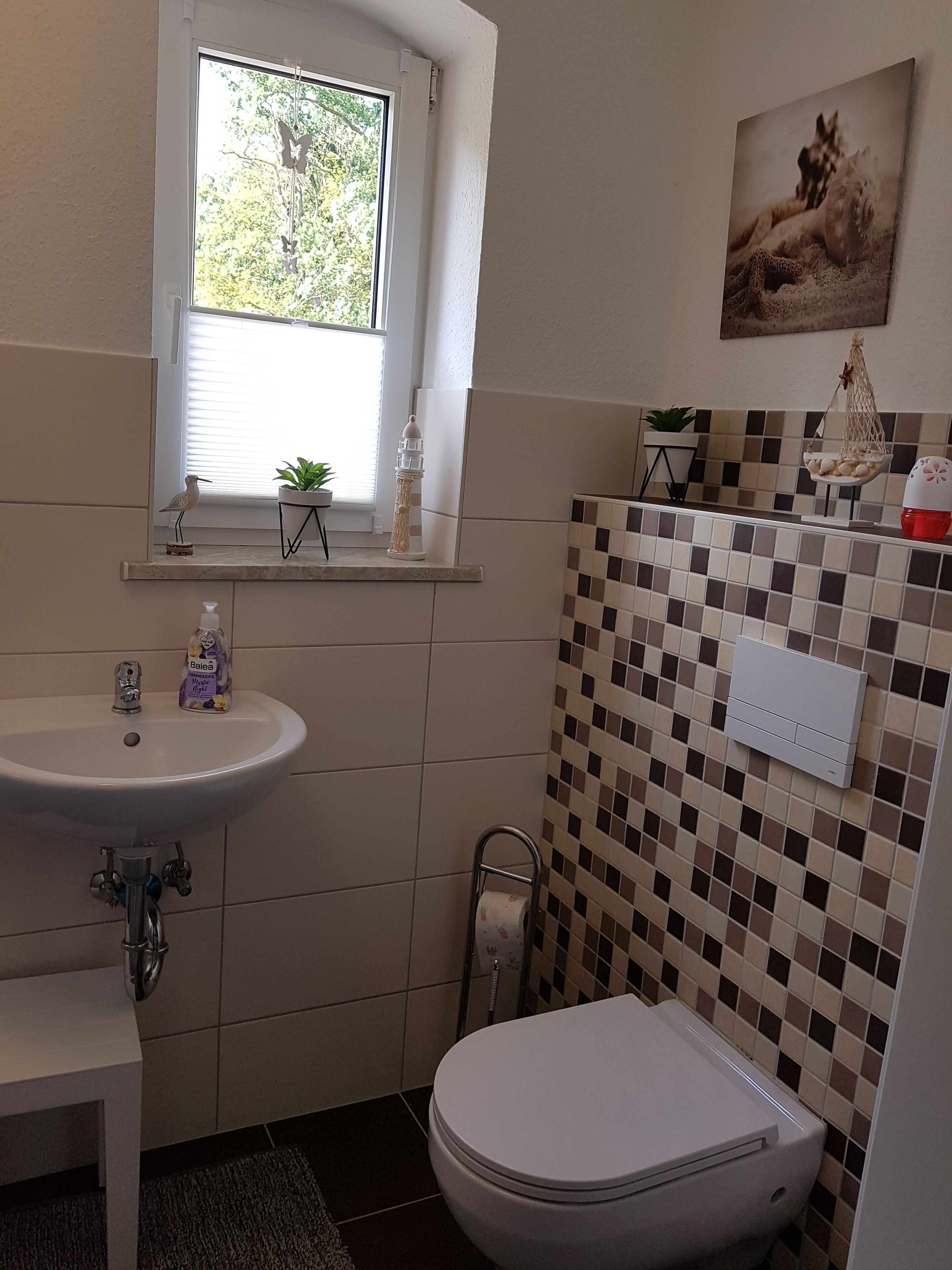 Un ba ño con lavamanos, inodoro y ventana.
