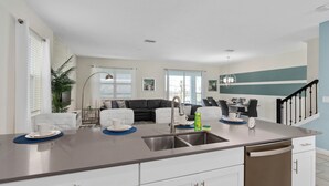 A modern kitchen with a central island, white cabinetry, and a stainless steel sink. - 8 Bedroom Home inside the best resort in Orlando, GOLF VIEW! (Four Corners)
