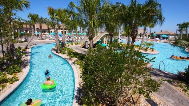 A pool area with multiple swimming lanes, palm trees, and lounge chairs. - 8 Bedroom Home inside the best resort in Orlando, GOLF VIEW! (Four Corners)