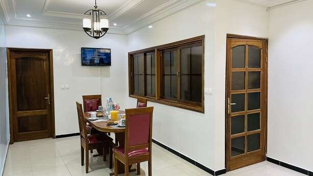 Un comedor con una mesa de madera, sillas y un televisor montado en la pared.
