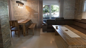Un salon chaleureux avec un banc en bois, un canapé et une table à manger.
