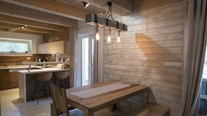 Une cuisine moderne avec des meubles en bois, un îlot central et des luminaires suspendus.