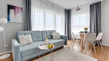 Apartemen Deluks, 1 kamar tidur, pemandangan kota | Ruang keluarga | TV layar datar