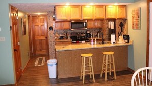 A kitchen with wooden cabinets, a microwave, a coffee maker, and two stools. -  2 minutes to Parkway, 5 minutes to The Island & Dollywood!  (Pigeon Forge)