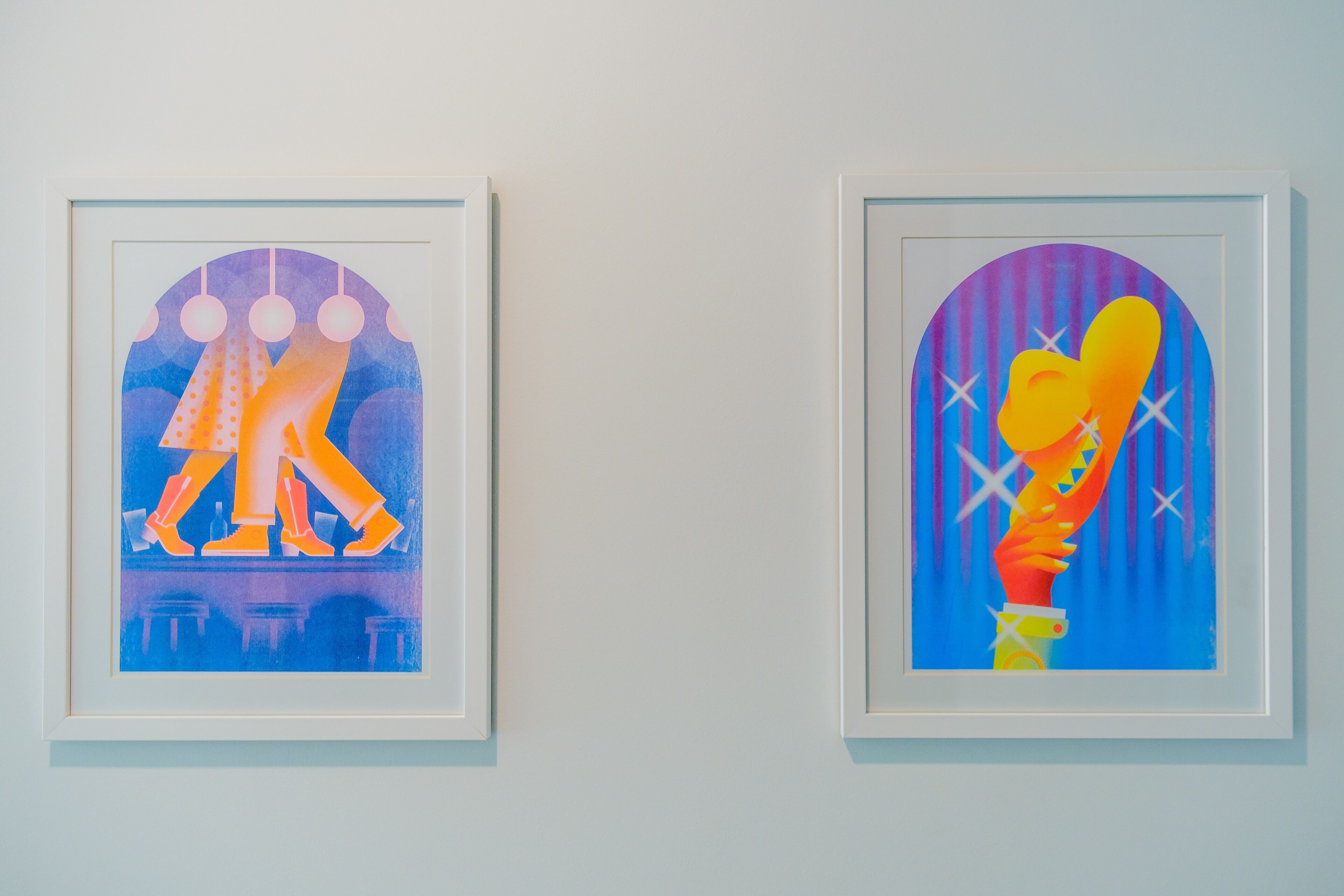 Deux œuvres d’art encadrées sont accrochées au mur.