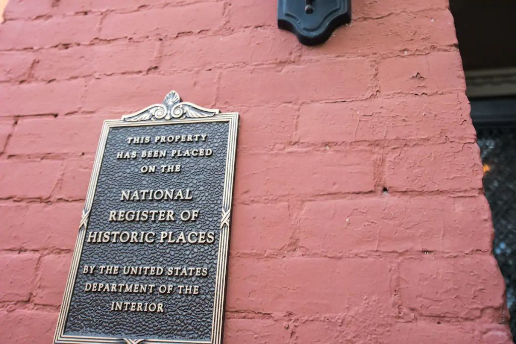 Placa em uma parede de tijolos informando que o imóvel está no Registro Nacional de Lugares Históricos.