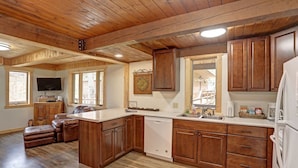 A spacious kitchen with wooden cabinets, a built-in dishwasher, and a large island. - Trail Mountain Cabin – Stunning Views, Hot Tub & Game Room (Lead)