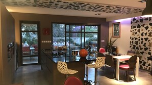 A modern interior with a central island, bar stools, and a dining area with chairs. - Meltime Share Mélanie's living space (Nîmes)