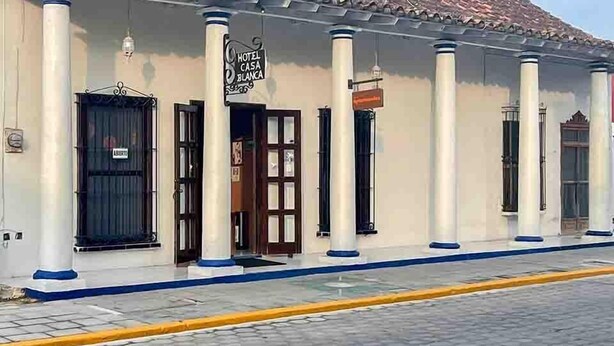 A building with a sign reading "Hotel Casa Blanca" and a closed door with a sign that says "ABIERTO" (open).