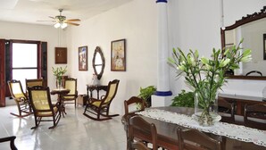 A dining area with wooden furniture, a ceiling fan, and a large mirror.