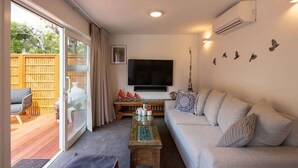 Ein Wohnzimmer mit Sofa, Fernseher und Couchtisch.