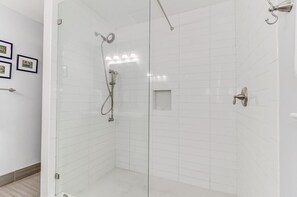 Een bad/douchecombinatie, handdoeken