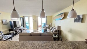 A spacious living area with a large granite countertop, a beige sofa, and a flat-screen TV. - Sabine 6E- Sleeps 6 Gulf View Pensacola Beach Condo (Pensacola Beach)