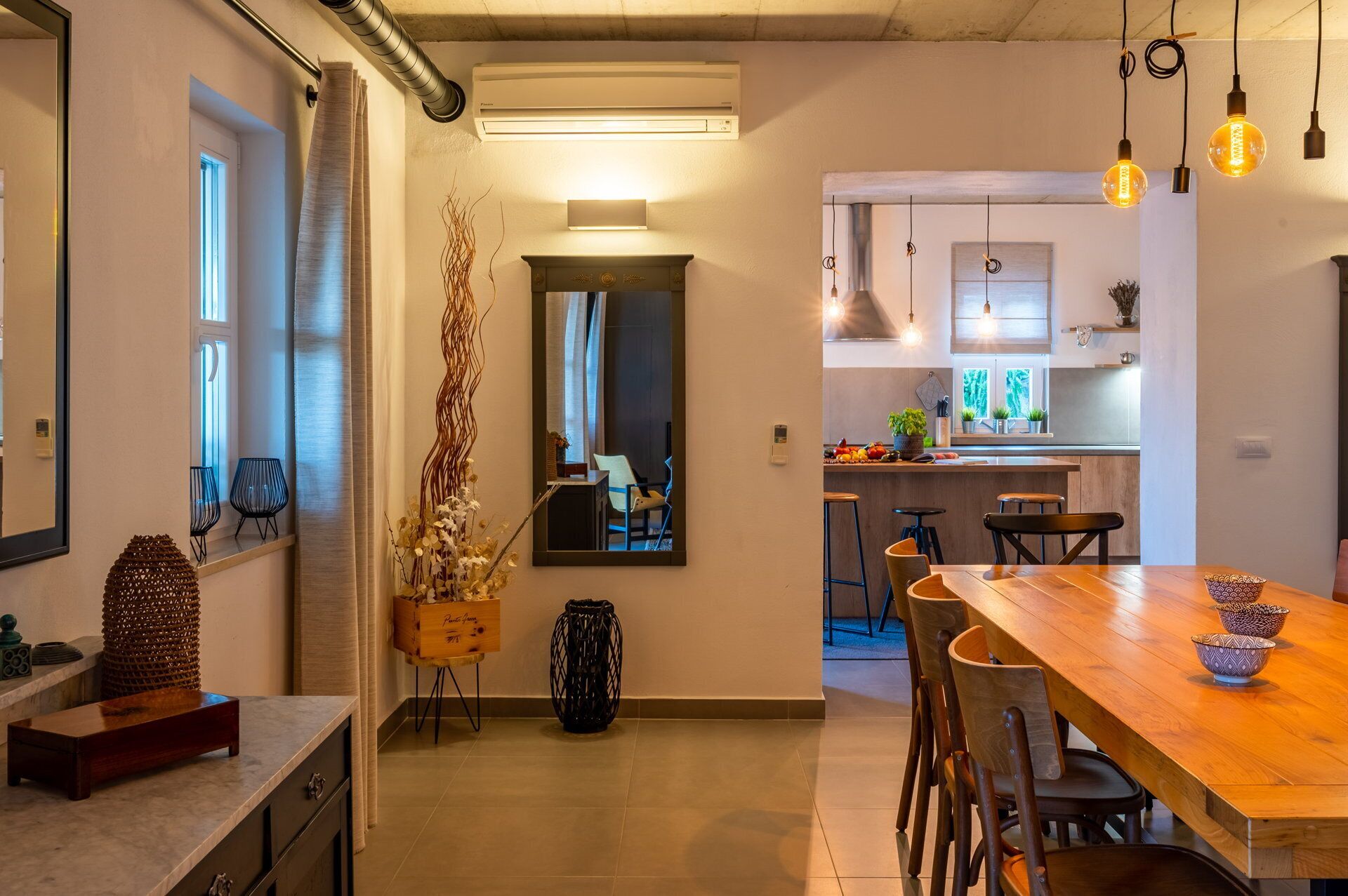 Una cocina moderna con una mesa y sillas de madera, un horno empotrado y una ventana con vistas al jardín.