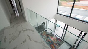 A modern interior with a glass railing, a marble floor, and a colorful rug. - Villa Vagabundo with Pool (Zaton)