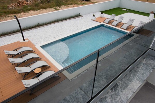 A rooftop pool with white lounge chairs and a wooden deck. - Villa Vagabundo with Pool (Zaton)