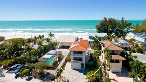 A coastal residential area with houses, a swimming pool, and a beach.