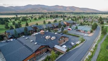 A lodge with multiple cabins, a parking area, and a large open field in the background.