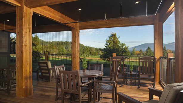 A wooden deck with outdoor seating, overlooking a golf course and mountains. - Stoneridge Resort (Blanchard)