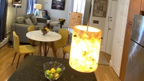 A modern kitchen with a dining area, a refrigerator, and a table with a bowl of fruit. - Exquisite 3rd Floor Private Apt with Style (Westfield)