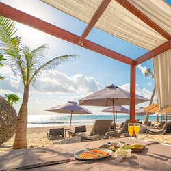Aan een privéstrand, wit zand, ligstoelen, parasols