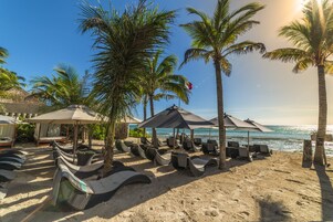 Privat strand, vit sandstrand, solstolar och parasoller