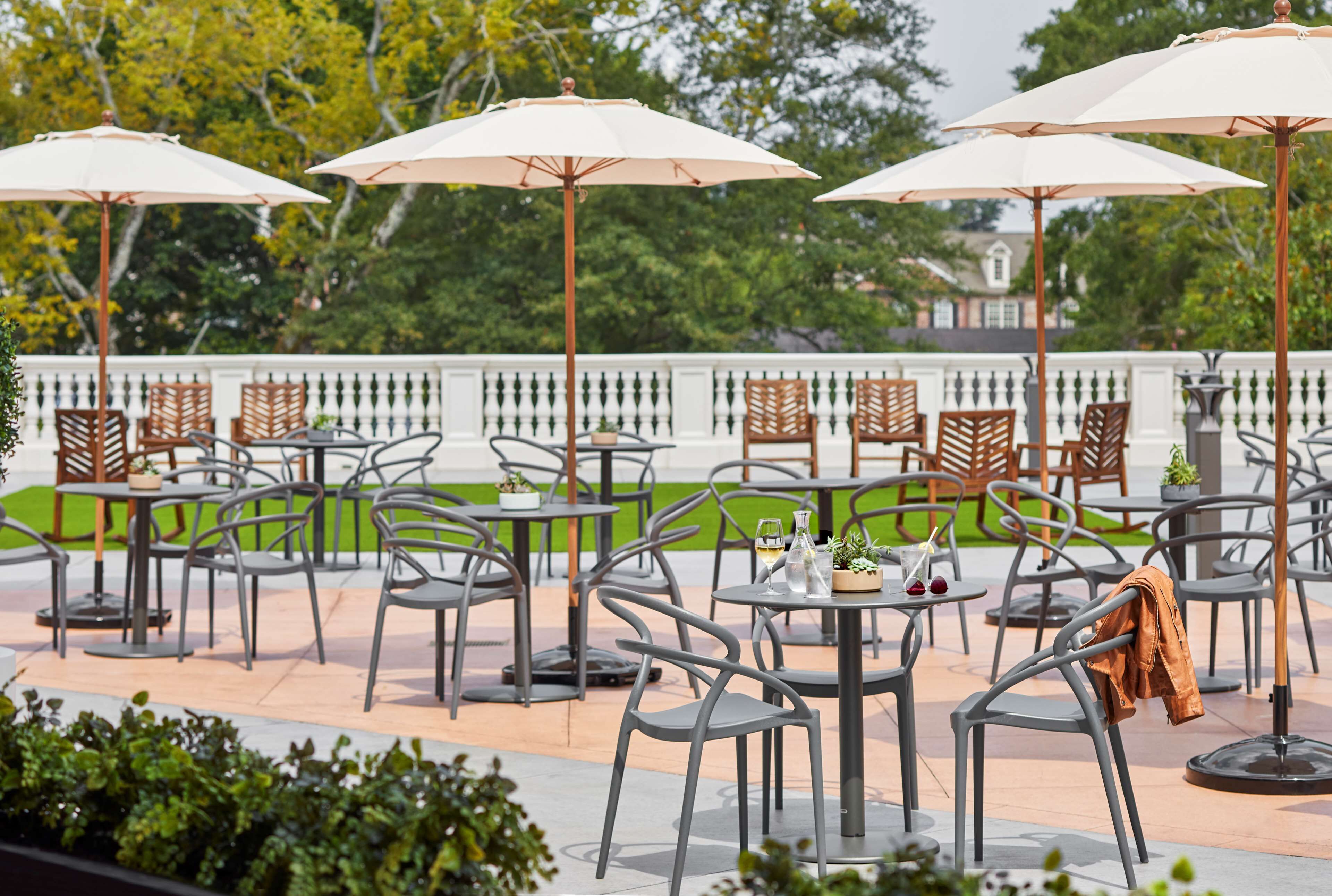 Outdoor seating with umbrellas, metal chairs, and tables.