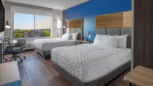 Una habitación de hotel con dos camas, un escritorio y una silla.