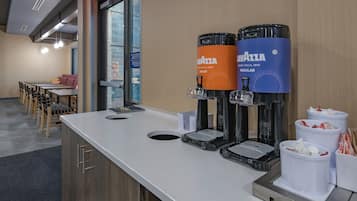 A self-service beverage station with two coffee dispensers and a coffee grinder.
