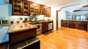 A kitchen with wooden cabinets, a stainless steel range, and a wooden island. - 2027 NOW OPEN! Harbert Home With Hot Tub & Close To Beach! (Harbert)