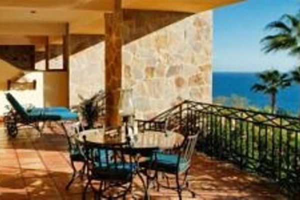 The spacious porch overlooking the beach and ocean invites lounging and dining.