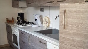 Una cocina moderna con armarios de madera, estufa a gas, lavavajillas y un fregadero.
