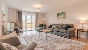 A modern living room with a sofa set, a coffee table, a TV, and a lamp. - Maple House - sleeps 9 guests  in 5 bedrooms (Ebrington)