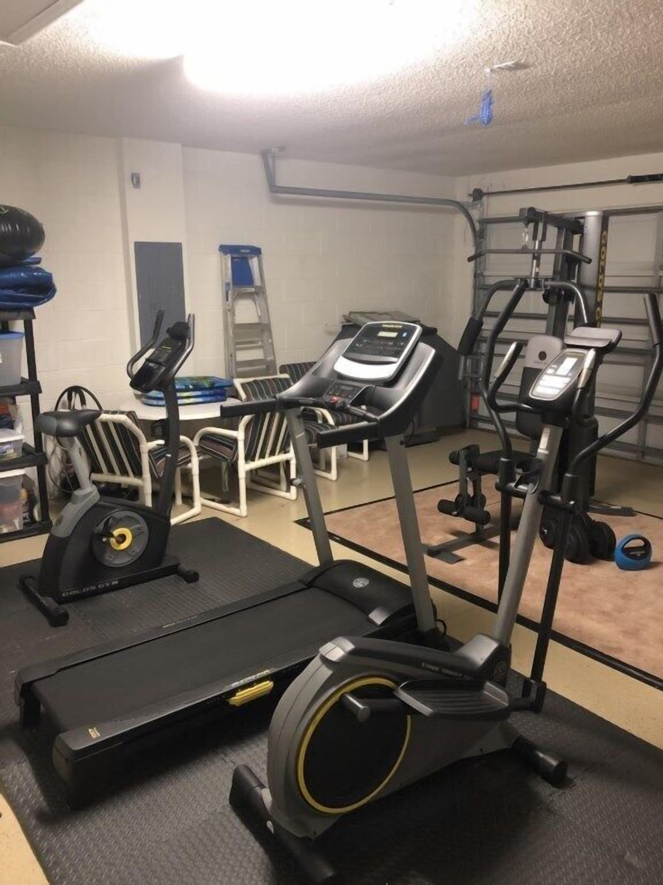 A gym with treadmills, elliptical machines, and weightlifting equipment.