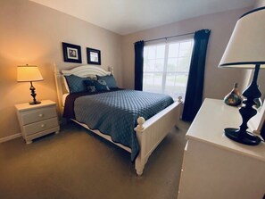 Una camera da letto con un letto, un comodino, una lampada e vista sull'esterno.