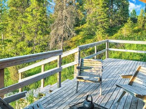 A wooden deck with a bench and a kettle, surrounded by lush greenery. - Villa jaloranta a by Interhome (Kuusamo)