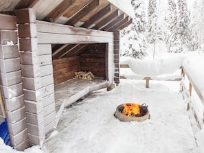 Una cabaña de madera con chimenea y fachada cubierta de nieve.