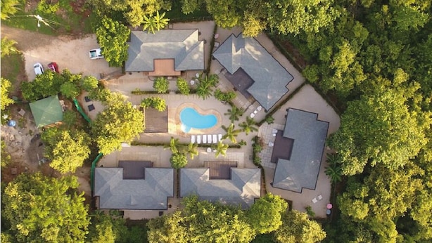 An aerial view of a residential area with multiple houses, a swimming pool, and surrounding greenery. - Luxury villas Playa Avellanas (Guanacaste)