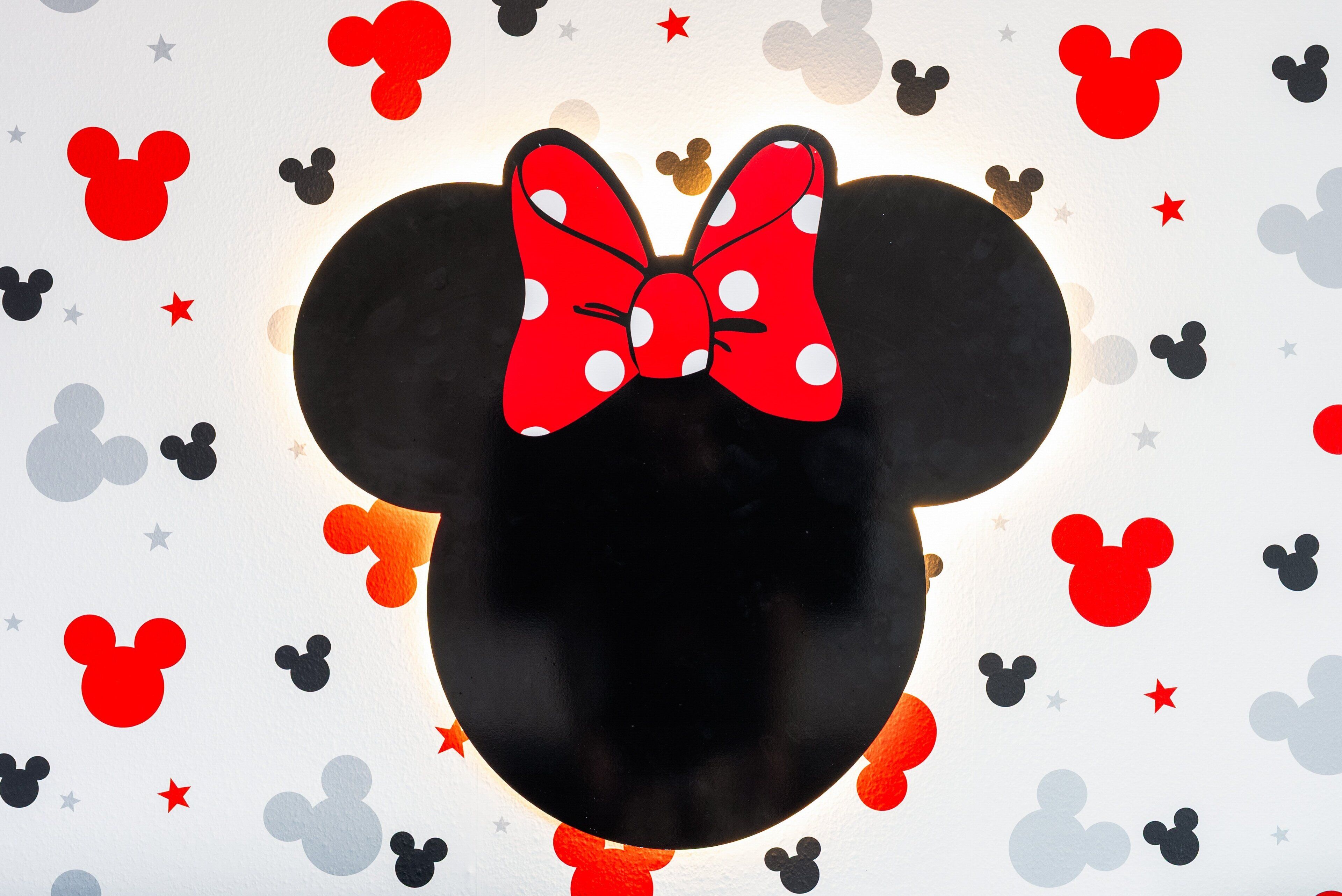 A graphic of a cartoon character's head with a bow, surrounded by various shapes and stars.
