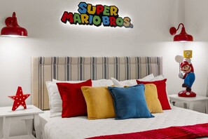 A bedroom with a bed, pillows, a Mario figurine, and a wall sign. - Amazing Disney Delight: 4BR, Pool, Near Parks - 2929 SS (Kissimmee)