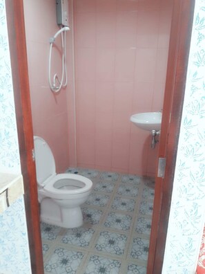 A small bathroom with a toilet, a sink, and a shower. - Manowwhan Homestay (Kaeng Krachan)